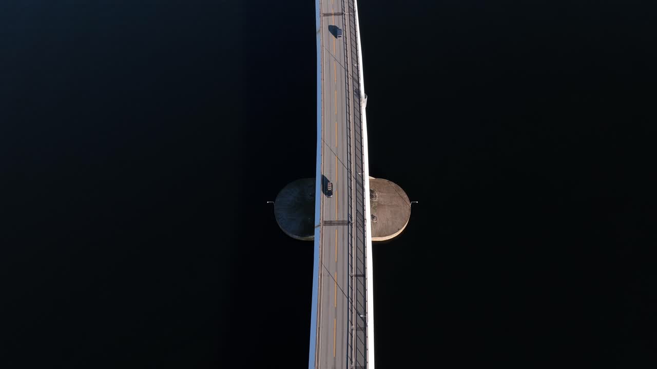 una imagen aérea de arriba hacia abajo del tráfico en el puente de nordhordland, inclinándose hacia arriba para revelar la torre del puente y la carretera hacia hordvik