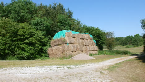 a haystack covered with a tarpaulin in a farm field