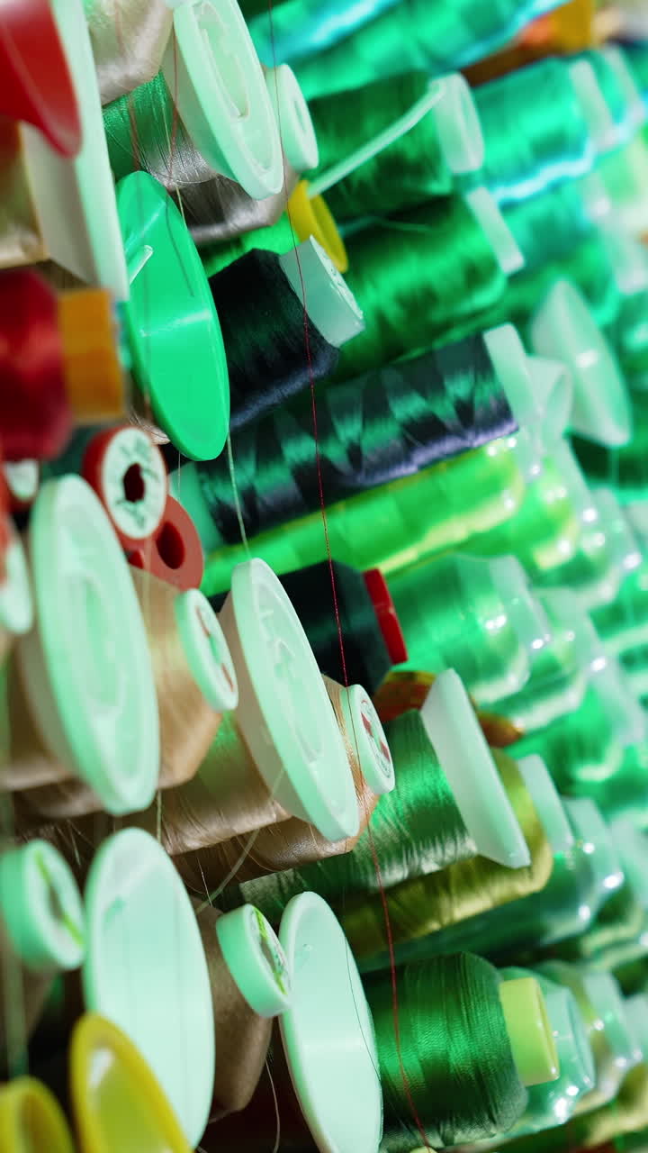 Rolls of threads hanging on a wall. Colorful sewing tools on a wall. Vertical video