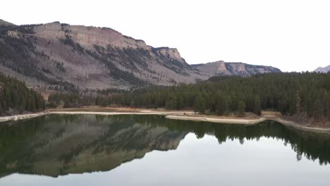 Mountains-with-calm-lake.-Drone-moving-across-lake