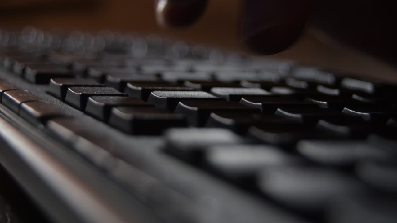 Fingers writing in a black computer keyboard. Loop