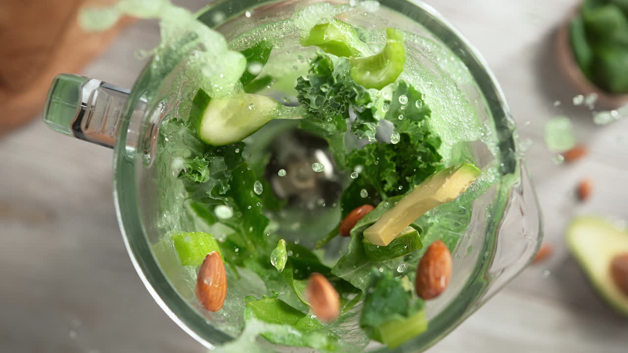 녹색 디스 아보카도 스무디는 유리 블렌더에 여 느린 동작으로, 위쪽 뷰, 장치 내부