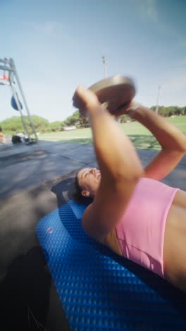 woman exercising outdoors with weights