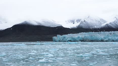 Snowcapped-mountains-behind-a-glacier-and-icy-sea