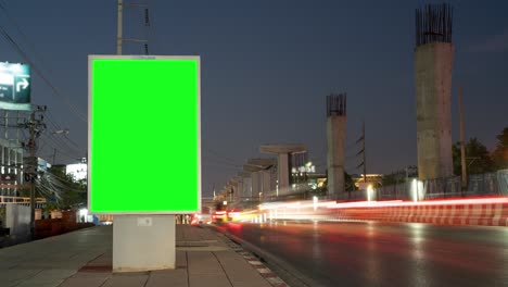 time lapse, traffic long exposure on road with billboard green screen use for advertising street signs in city.