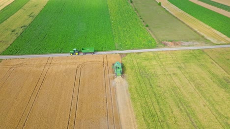 aerial view of harvesting machine working in the field - drone shot