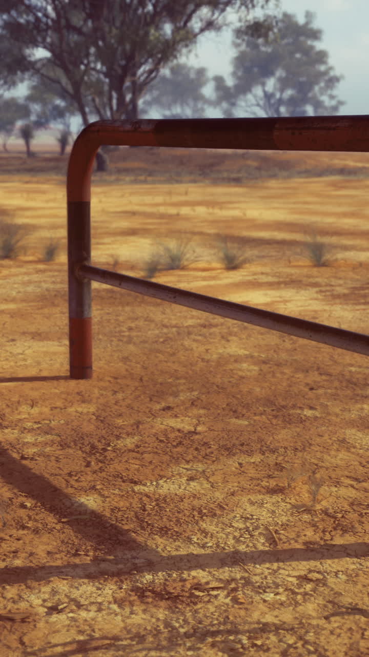 Metal structure on dry cracked earth in a barren landscape during sunny weather