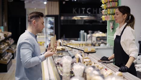 a visitor chooses a product in a confectionery. going to the store, buying cakes and pastries