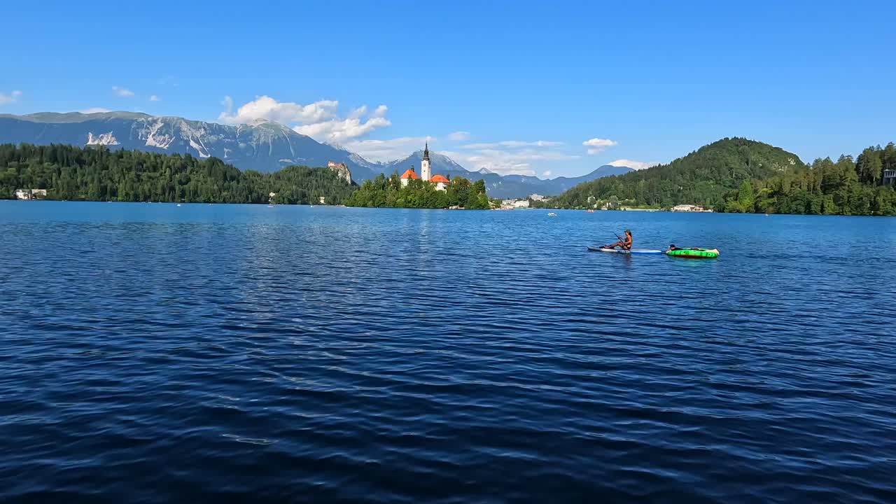Malerische Ausblicke auf den Bleder See mit Inselkirche und Paddleboarding