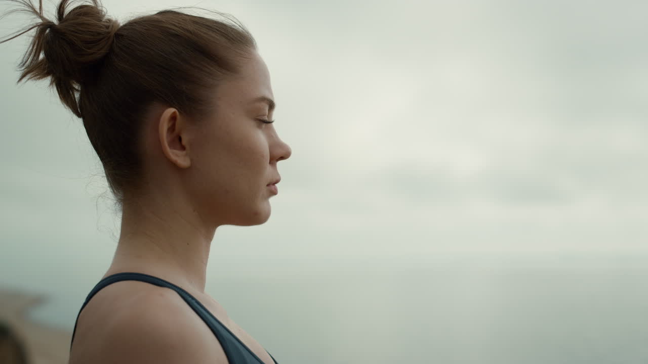 chica de primer plano sentada en la orilla del mar. mujer meditando disfrutando de la naturaleza.