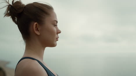 closeup girl sitting seashore side view. meditating woman enjoying nature.