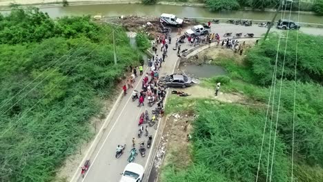 aerial view of people aiding unconscious people, due to a collision accident, in asia - descending, drone shot