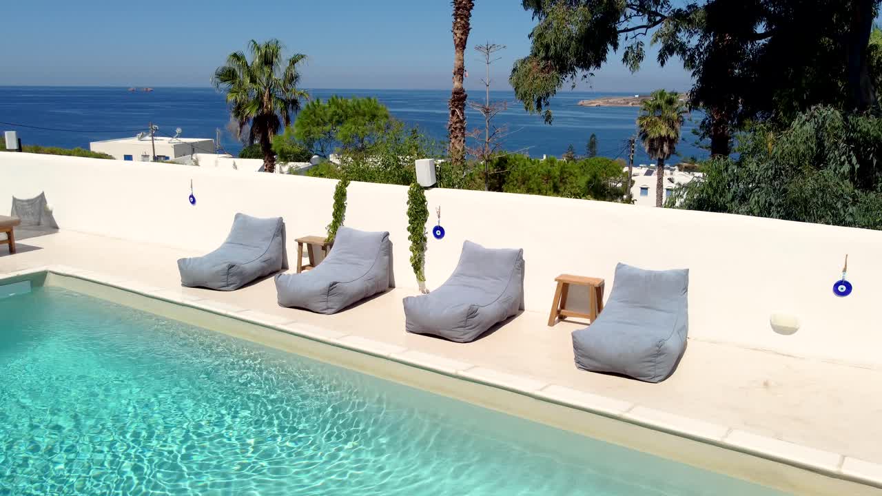Woman relaxing by a pool overlooking the ocean