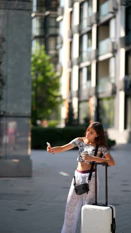 young woman taking a selfie with luggage