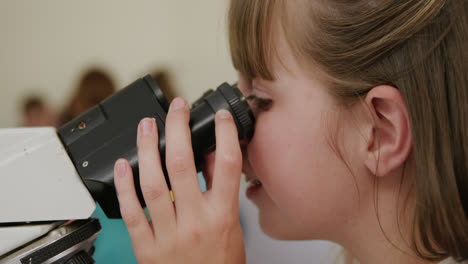 niña usando el microscopio