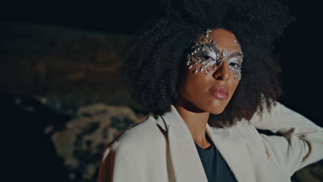woman posing art makeup at night closeup. fabulous party girl dancing dark beach