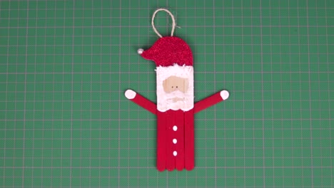 figure of santa claus made with popsicle sticks on a cutting mat