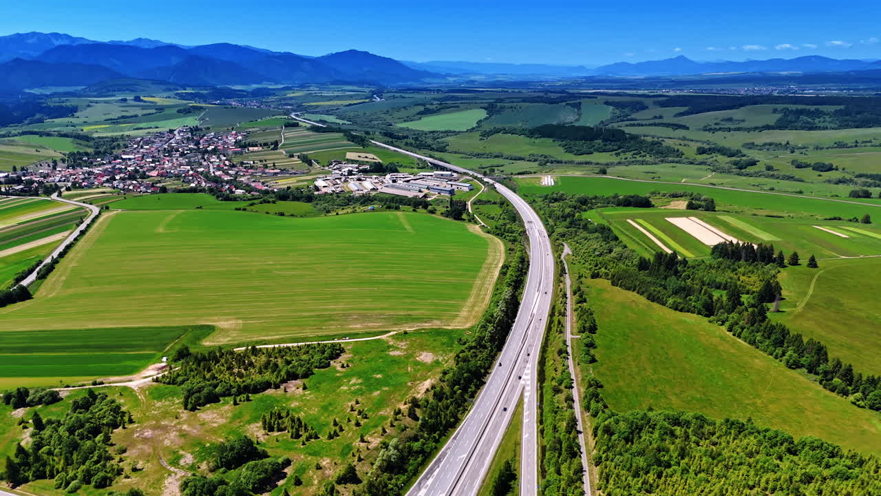 Stunning green nature landscapes crossed by the modern highway. Aerial view on the lovely village in Slovakia