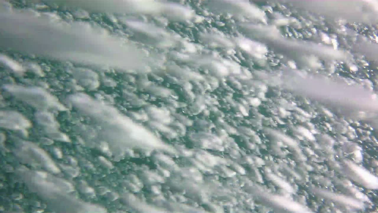 A cascade of bubbles from a scuba diver envelopes camera's point-of-view.