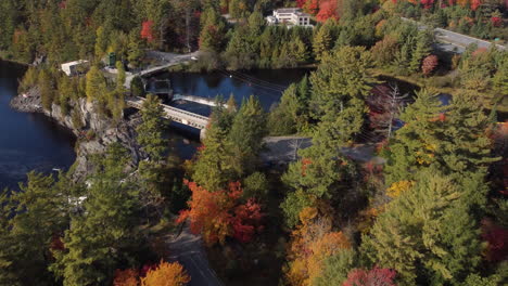 drone-flight-to-a-water-basin-with-waterfall-over-a-forest-in-colorful-autumn-colors