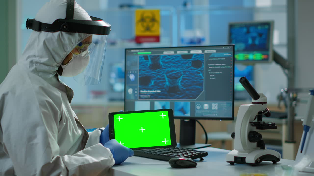 médico con camiseta trabajando en una tableta con pantalla verde