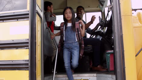 jóvenes niños de escuela primaria bajando de un autobús escolar