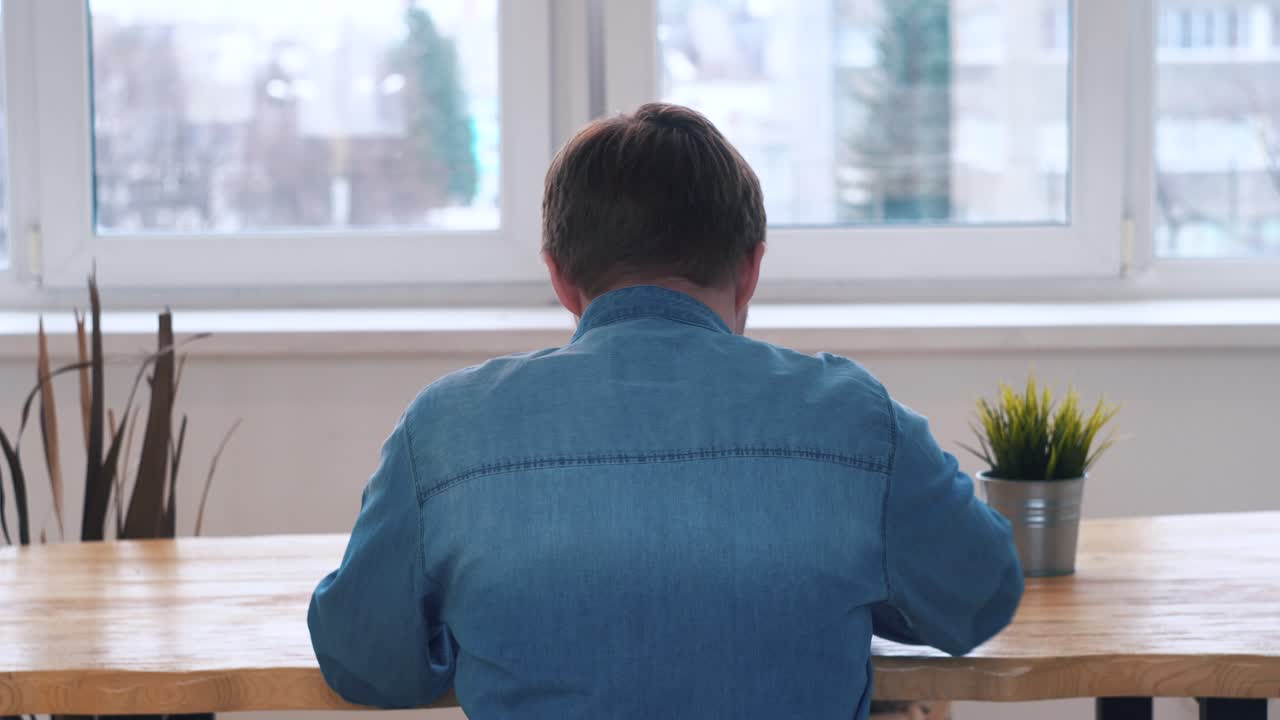 창밖을 바라보는 테이블에 앉아 있는 남자