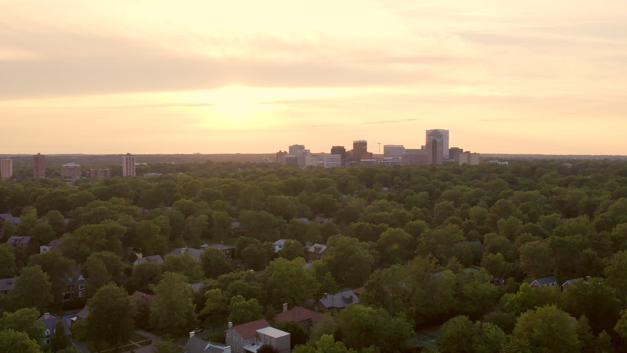 멋진 집들이 있는 예쁜 동네 위로 클레이튼 스카이라인과 일몰을 향해 밀어붙입니다.