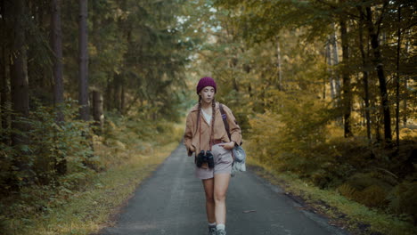 woman with hands in pockets walking on road