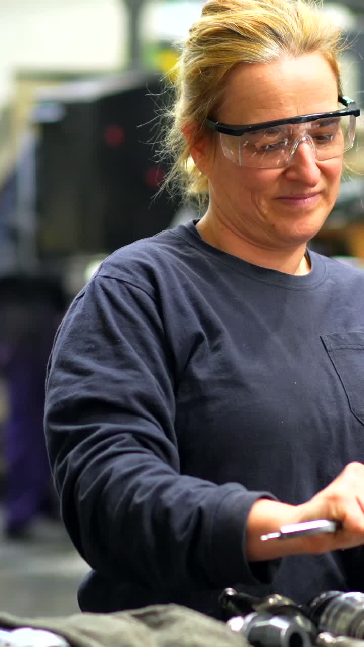 Frau in Produktionsumgebung mit Messwerkzeug