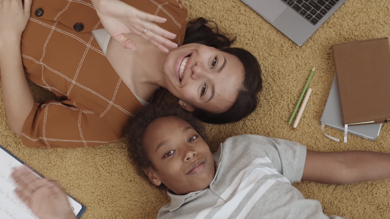 madre e hijo haciendo la tarea juntos en el suelo