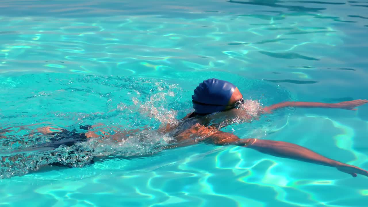 Fit swimmer doing the breast stroke in the swimming pool