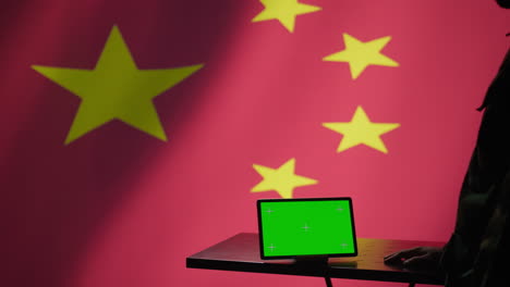 operador de la agencia de inteligencia china usando una tableta de pantalla verde para hacer propaganda