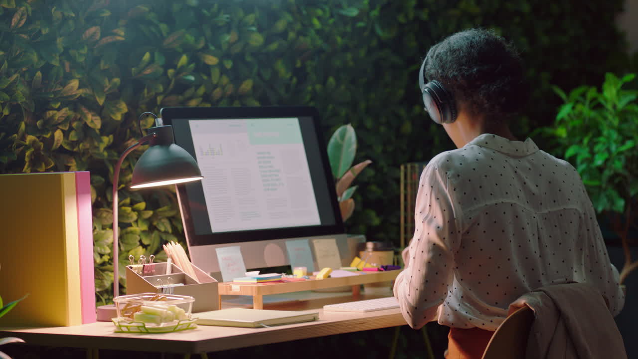 business woman working late drinking coffee using computer analyst browsing research statistics reading information data planning strategy in office at night wearing headphones