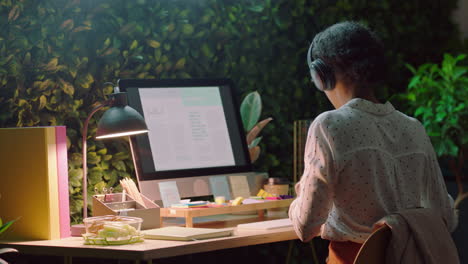 mujer de negocios trabajando hasta tarde bebiendo café usando analista de computadora navegando estadísticas de investigación leyendo información estrategia de planificación de datos en la oficina por la noche usando auriculares