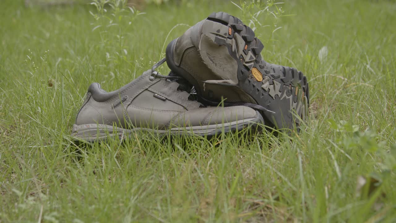 Wide dolly of hiking shoes thrown away in a green grass field