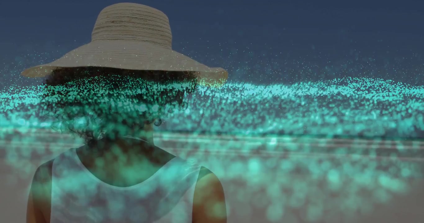 Woman standing facing ocean on beach observing emerging teal tech particle waveform pulsing horizon