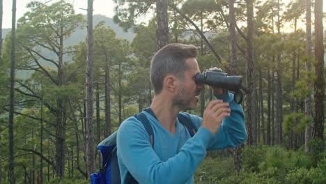 happy man admiring nature through binoculars