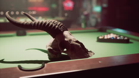 a skull with horns sits on a pool table