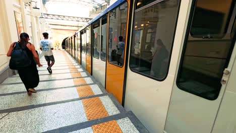 passengers approach and board a metro train