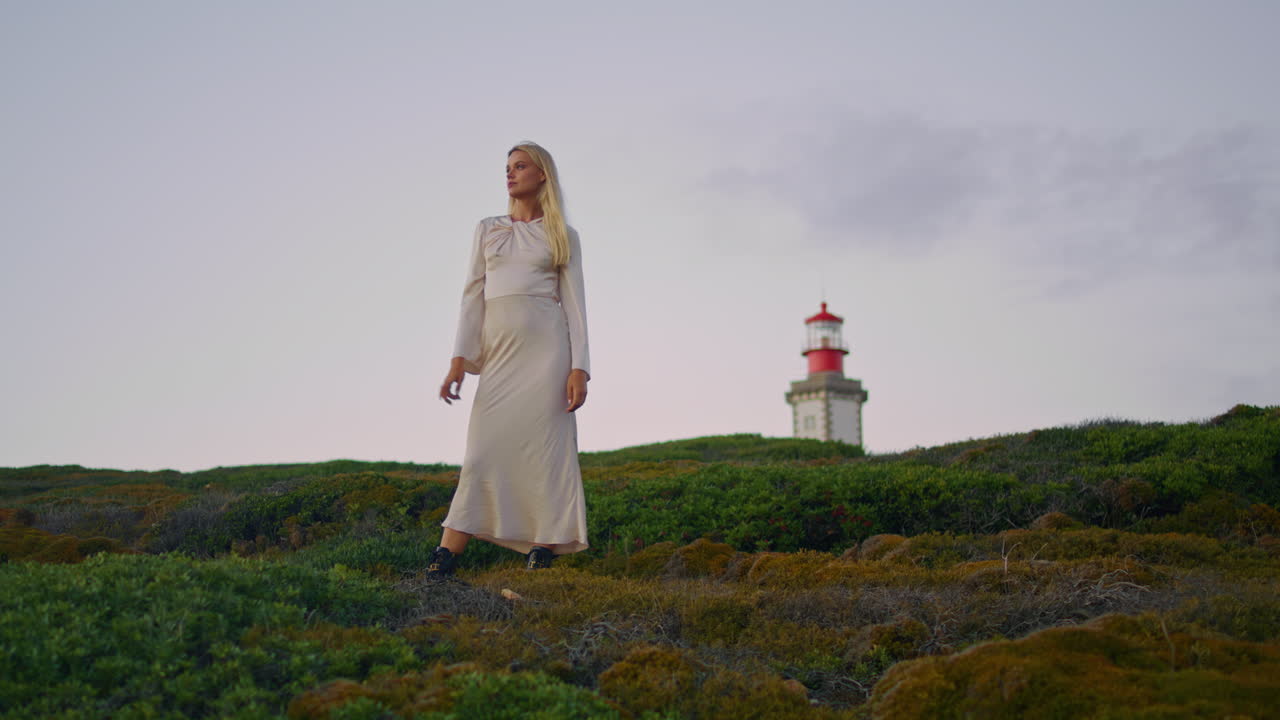 Beautiful woman admiring sunset vertical shot. Model straightens hair at sky