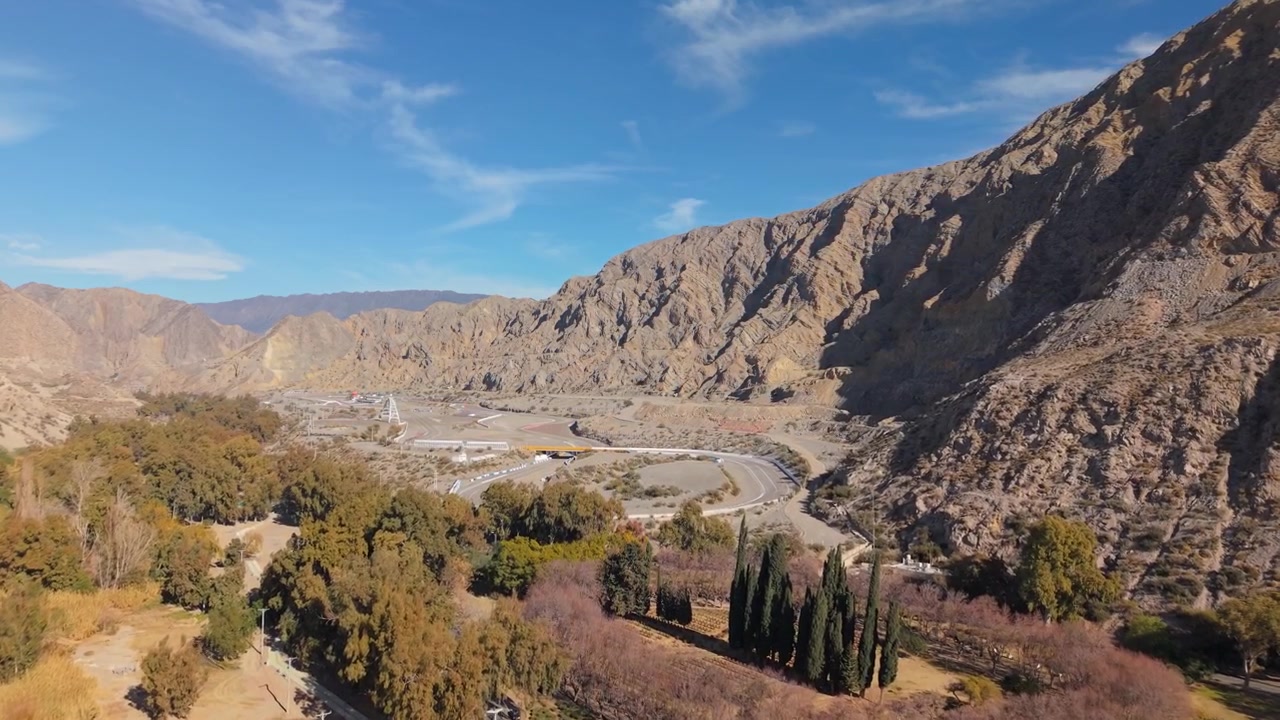 Autodromo Eduardo Copello El Zonda i Quebrada de Zonda, Rivadavia, San Juan, Argentina, som visar racerbanan, Andernas fot, Zondadalen och vingårdarna, drönaröverflygning framåt.