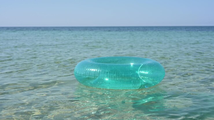 A blue inflatable ring floats in sea water