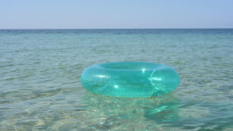un anillo inflable azul flota en el agua del mar