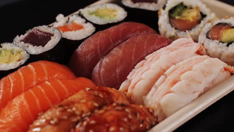 assorted sushi and sashimi platter in takeaway box