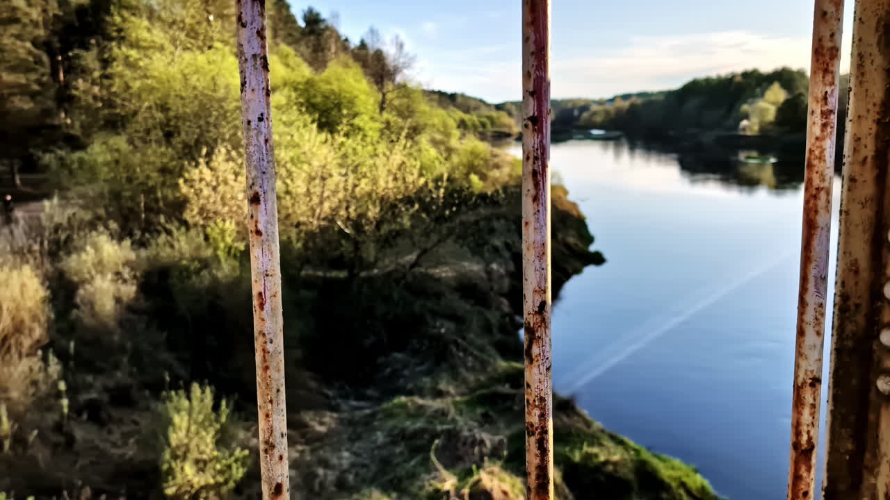 Closeup of rusty metal bridge railing over river in spring landscape