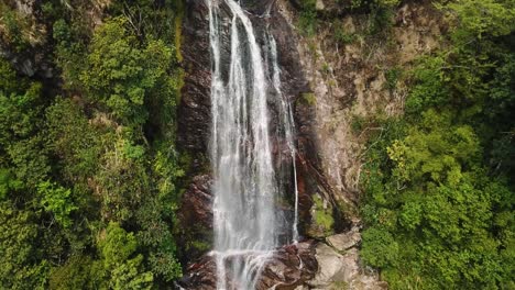 orbital aerial shot of a stringy waterfall in south east asia