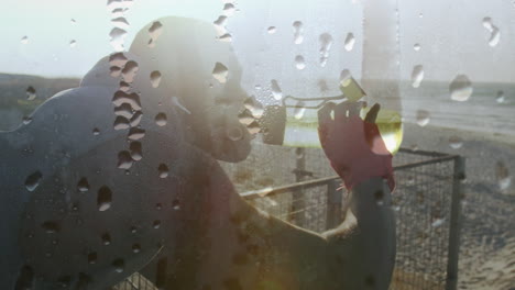 animation of drops of water over exercising african american man taking a break drinking water