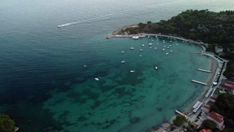 Aerial-Drone-shot-of-Mlini-bay,-with-the-boats-in-the-bay-and-the-beautiful-crystal-clear-blue-water,-Croatia