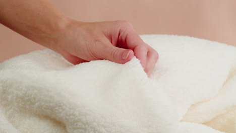 woman's hand touching a white fleece blanket